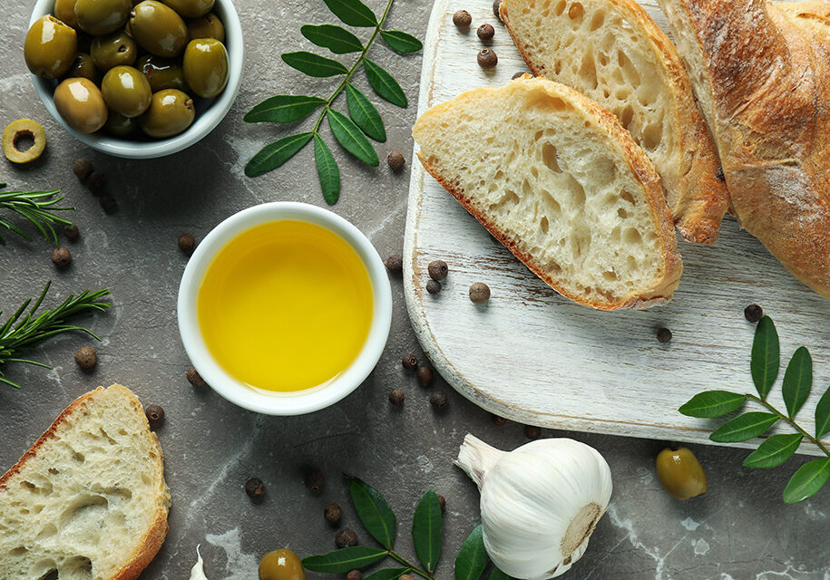 Concept of tasty eating with olive oil on gray textured table